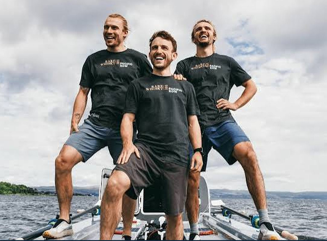 Ewan, Jamie and Lachlan Maclean standing aboard their ocean rowing boat